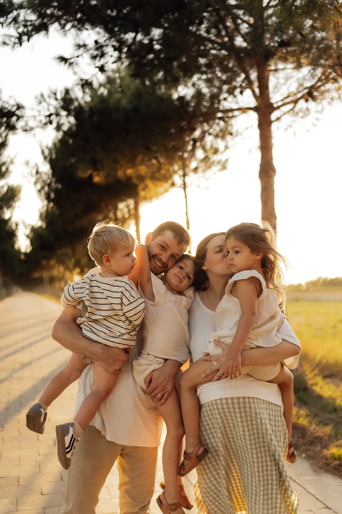 Familie mit Kindern umarmt sich im Abendlicht