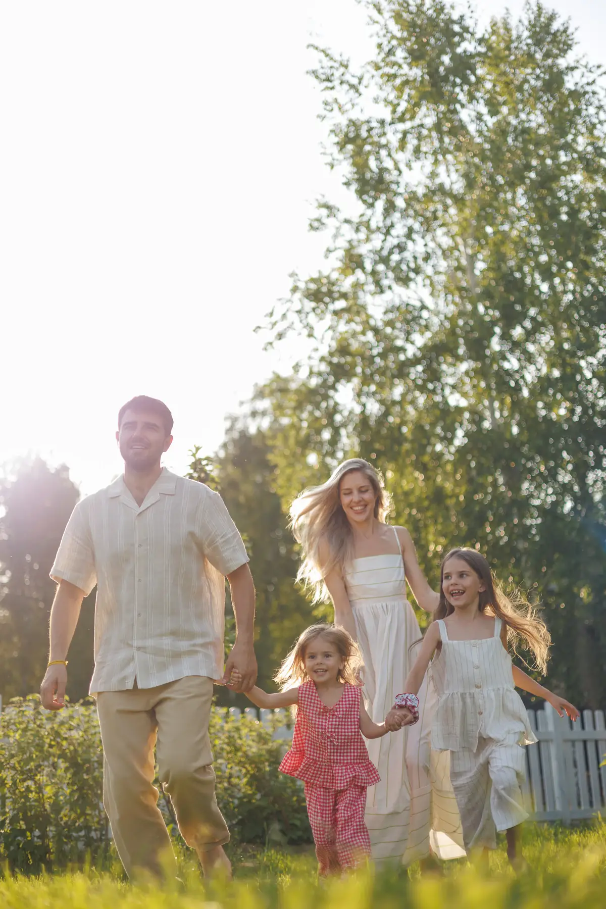 Familie geht gemeinsam durch einen sonnigen Garten